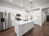 kitchen with quartz countertops, pendant lighting & white cabinets