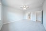 primary bedroom with carpet and ceiling fan