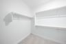 primary bedroom closet with carpet and white shelves