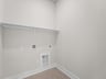 laundry room with brown flooring and shelving