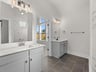 primary bathroom with dual sinks and a walk-in shower