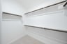 primary bedroom closet with carpet and white shelves