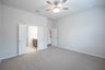 primary bedroom with carpet and ceiling fan