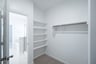 primary bedroom closet with carpet and white shelves