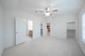 primary bedroom with carpet and ceiling fan