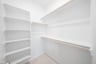 primary bedroom closet with carpet and white shelves
