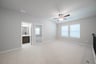 open loft with carpet, window, and ceiling fan