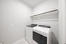 laundry room with tile floors and white shelf