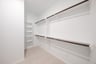 primary bedroom closet with carpet and white shelves