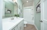 bath with mirror and white countertops