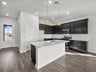 Kitchen with brown flooring, pendant lighting & quartz countertops