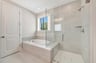 primary bath with a separate tub and shower