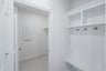 mudroom with wood floors and white shelves with bench