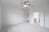 primary bedroom with carpet and ceiling fan