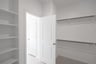 primary bedroom closet with carpet and white shelves