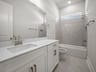 bathroom with quartz countertops & a bathtub with shower combo