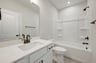 secondary bath with a shower and tub combo