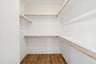 primary closet with wooden shelves