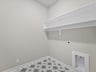 laundry room with patterned floor and storage space