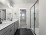 primary bathroom with black flooring, dual sinks and walk in shower 