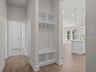 foyer with brown flooring and white cabinets