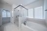 bathroom with large soaking tub and walk-in shower 
