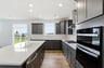 kitchen with dark gray cabinets and a white tile backsplash