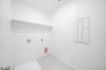 laundry room with tile floors and white shelf