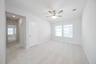 open loft with carpet and ceiling fan