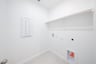 laundry room with tile floors and white shelf