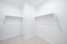 primary bedroom closet with carpet and white shelves