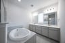 bathroom with large soaking tub and white countertops 