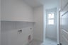 laundry room with tile floors and white shelf