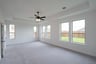 primary bedroom with carpet and ceiling fan