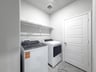 laundry room with washer dryer and a shelf 