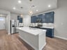kitchen with blue cabinets, pendant lighting & quartz countertops