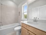 bathroom with quartz countertops, sink & a bathtub