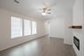 great room with windows with blinds and ceiling fan 