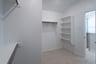 primary closet with carpet and white shelves