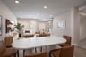 dining room with white oblong table, six brown chairs, and wood floors