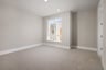 bedroom with tan carpet & walls, recessed ceiling lights, and window