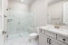 bathroom with white cabinets & counters, and large walk-in shower with seat and glass enclosure