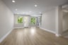 great room with wood floors, light tan walls, built in cabinets, and french door leading to covered deck