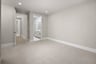 bedroom with light tan carpet & walls, recessed ceiling lights, and attached bathroom