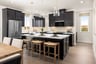 kitchen with black cabinets, white counters, wood floors, and three glass pendant lights above island
