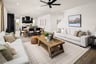 great room with two white sofas, wood coffee table, and black ceiling fan