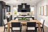 kitchen with black cabinets, white counters, wood table with six black & white chairs, and windows