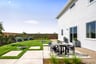 backyard with grass, concrete with round table & four gray chairs, and raised garden beds