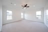 primary bedroom with carpet and ceiling fan