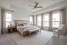 spacious primary bedroom with carpet and windows